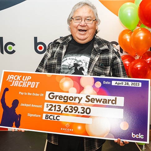 Gregory Seward holding the Jack Up The Jackpot cheque